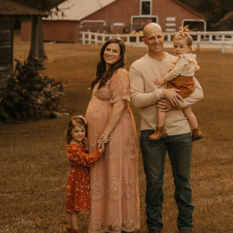 Dr. Nicole McDonald, pregnant with her third baby, with her husband and their two daughters